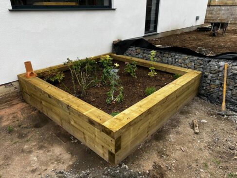 indian sandstone patio with railway sleeper flower bed 17